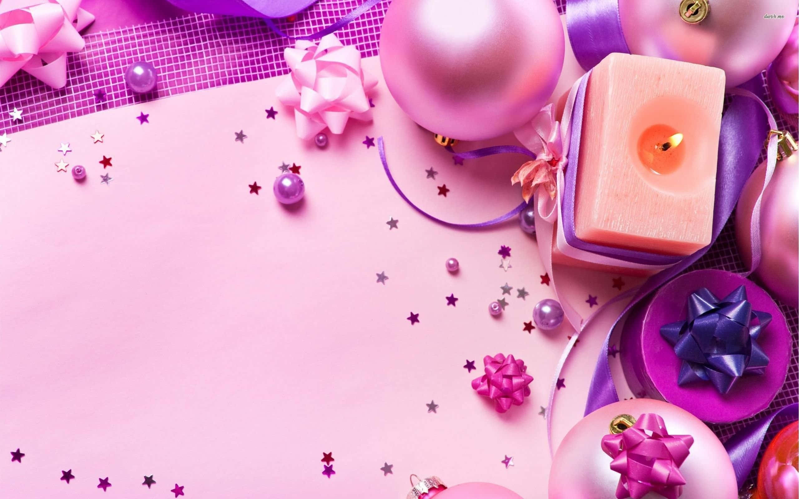 聖誕節 iPhone 桌布 壁紙 — 一個節日粉紅色和紫色的假期佈置，包括氣球、蝴蝶結、蠟燭和星星，在柔和的粉紅色背景上。