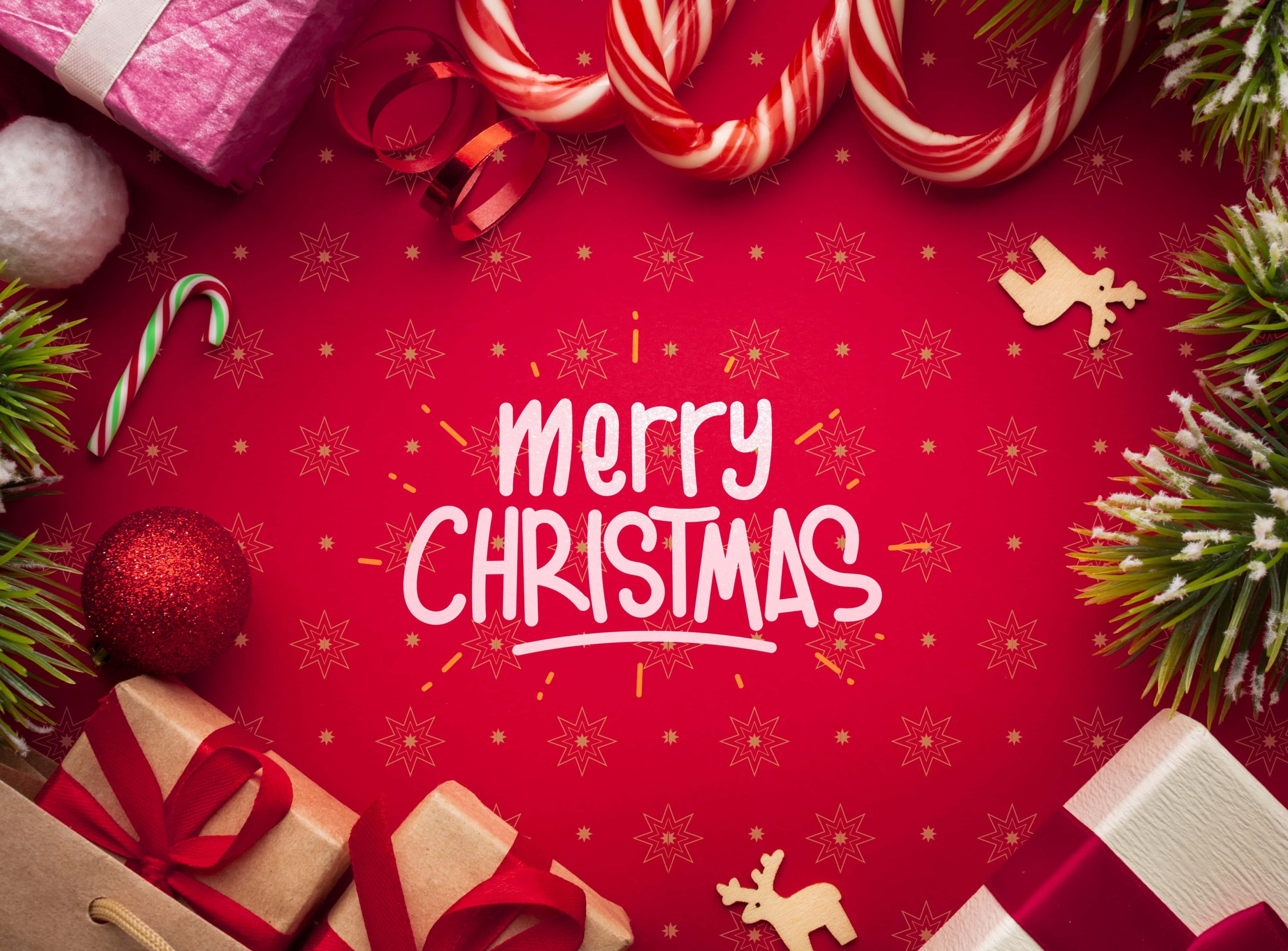 Christmas Red 桌布 壁紙 — 一個節日紅色背景，裝飾著拐杖糖、松樹枝、禮物和粗體的聖誕快樂文字。