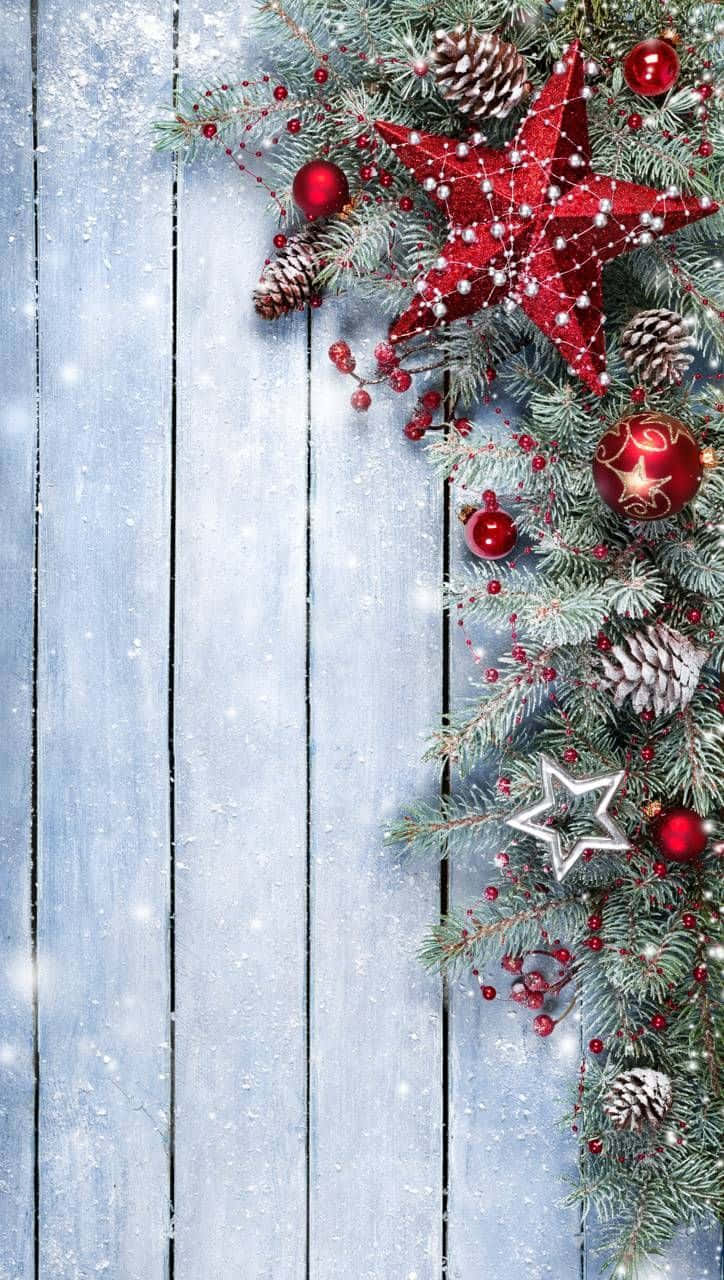 fence 桌布 壁紙 — 一個節日聖誕角落，紅色裝飾品、松果和星星點綴在積雪的藍色木板上。