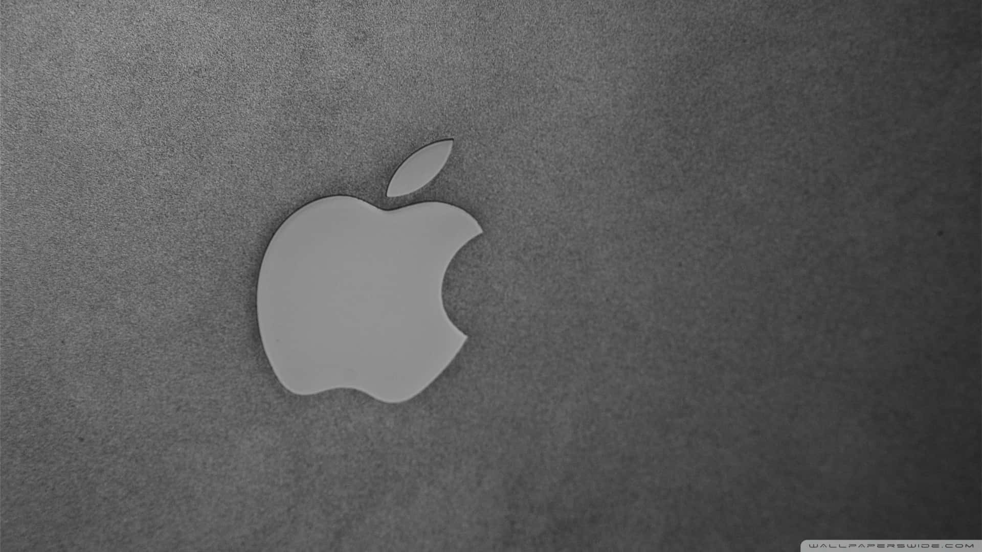Black Apple Logo 桌布 壁紙 — 一個簡約的灰色 Apple 標誌放置在帶有紋理的深灰色表面上，光線柔和。