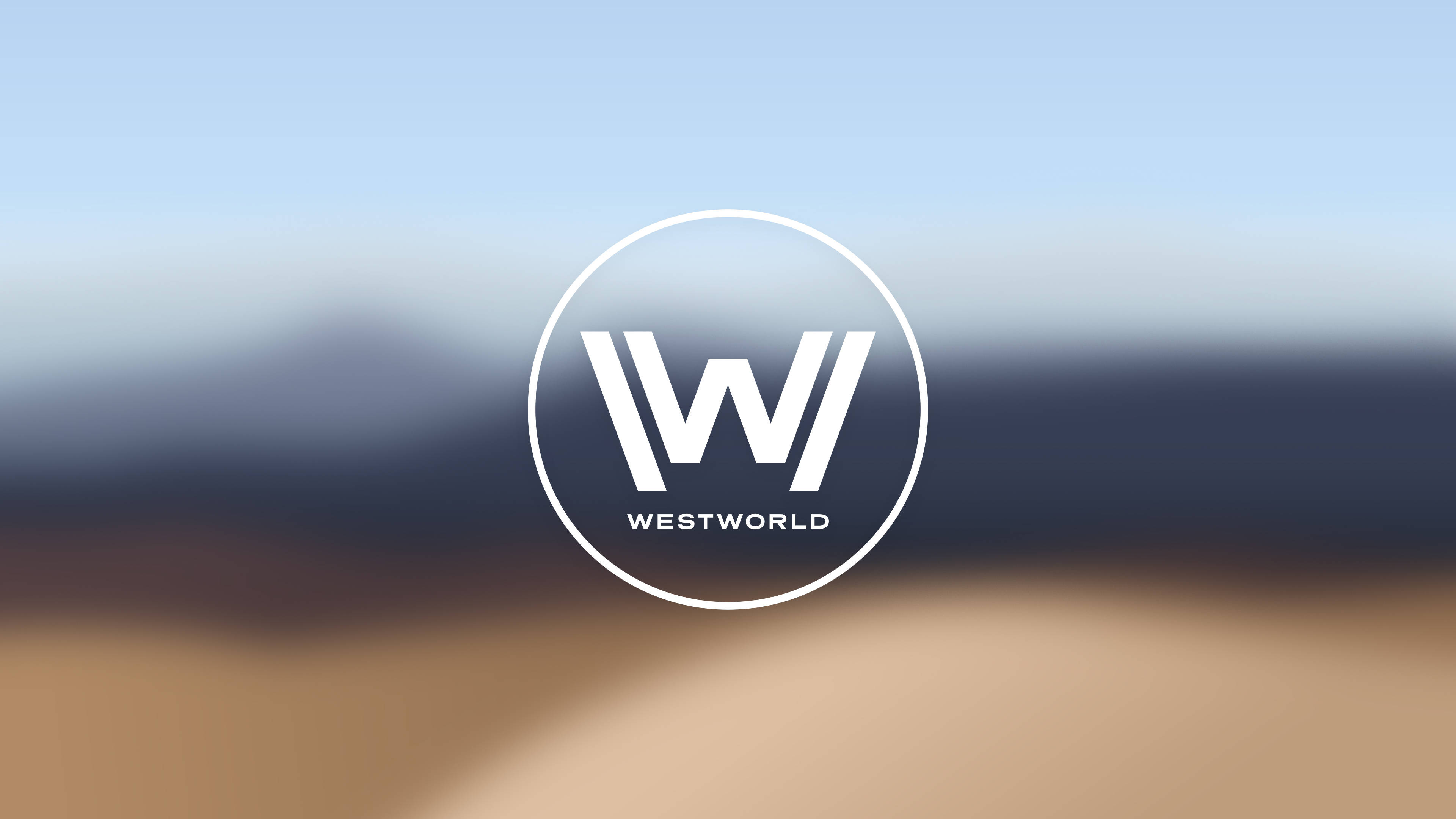 Westworld 桌布 壁紙 — 一個簡約的白色Westworld標誌，置中於模糊的沙漠景觀上，背景是柔和藍天。