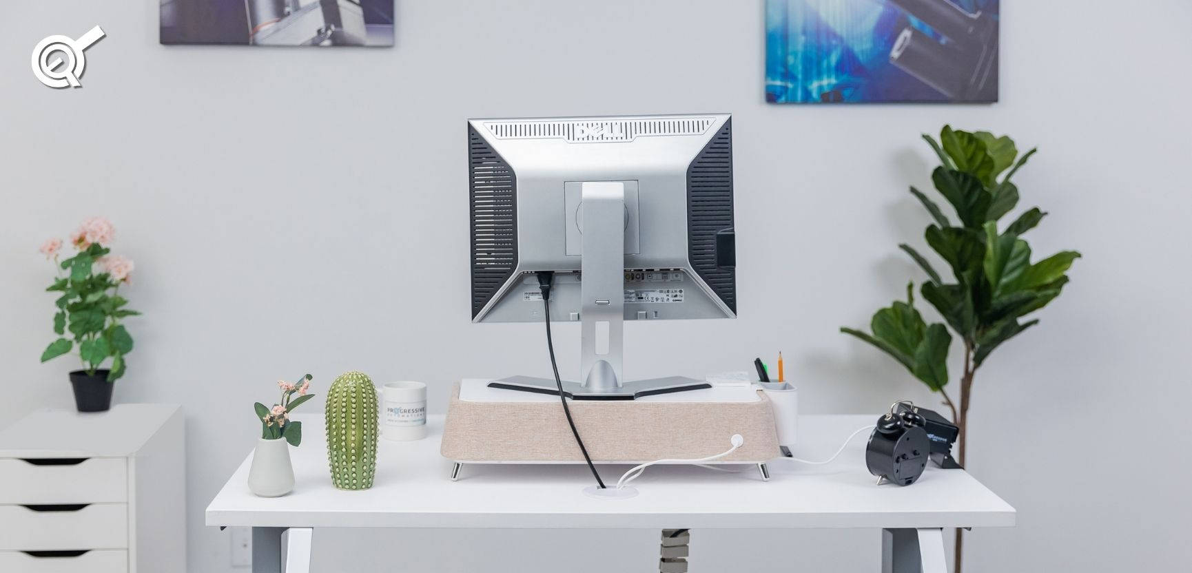 White Pc 桌布 壁紙 — 一個簡約的白色桌面設置，配有顯示器、相機、植物和仙人掌，在柔和日光下。