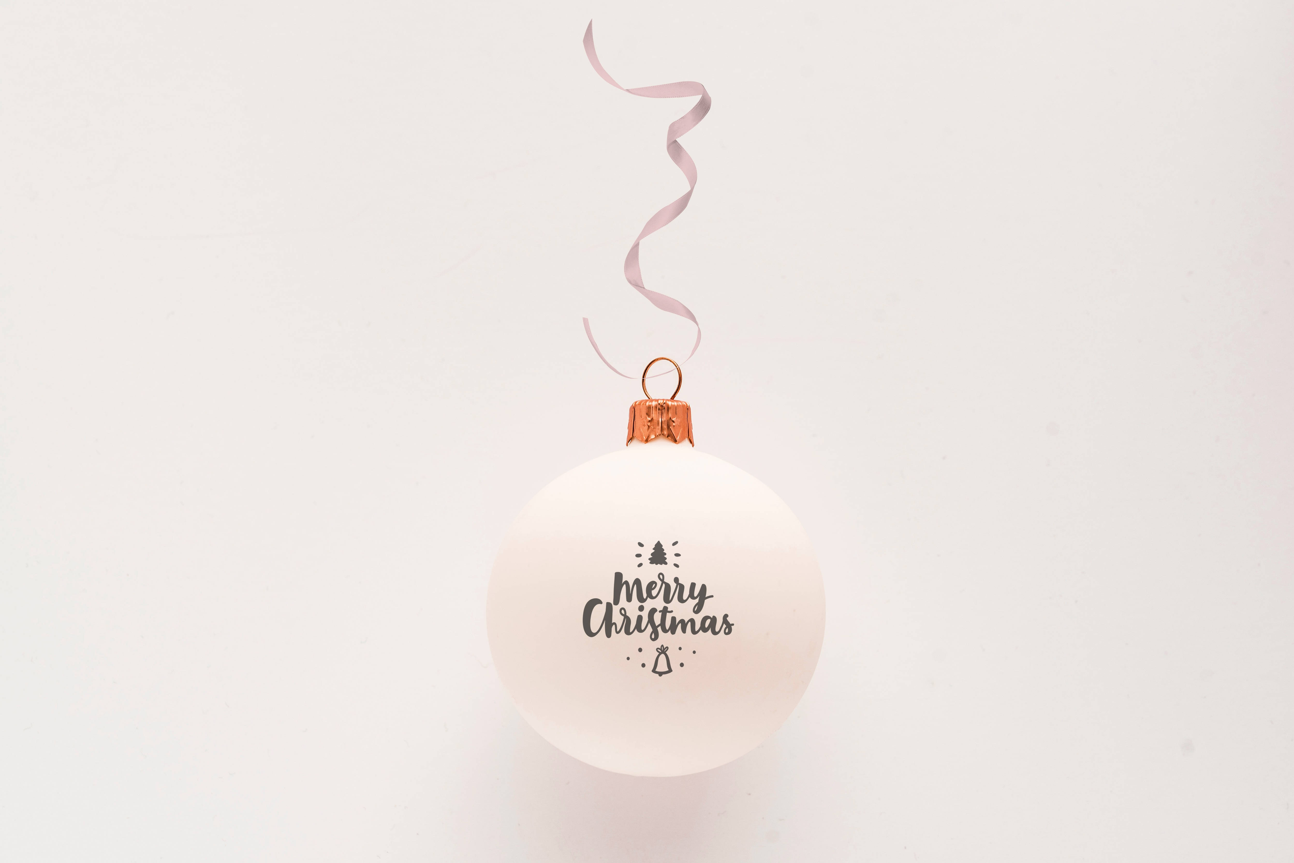 白色 桌布 壁紙 — 一個簡約的白色聖誕裝飾，上面有「Merry Christmas」文字和小圖標，掛在純白色背景上。