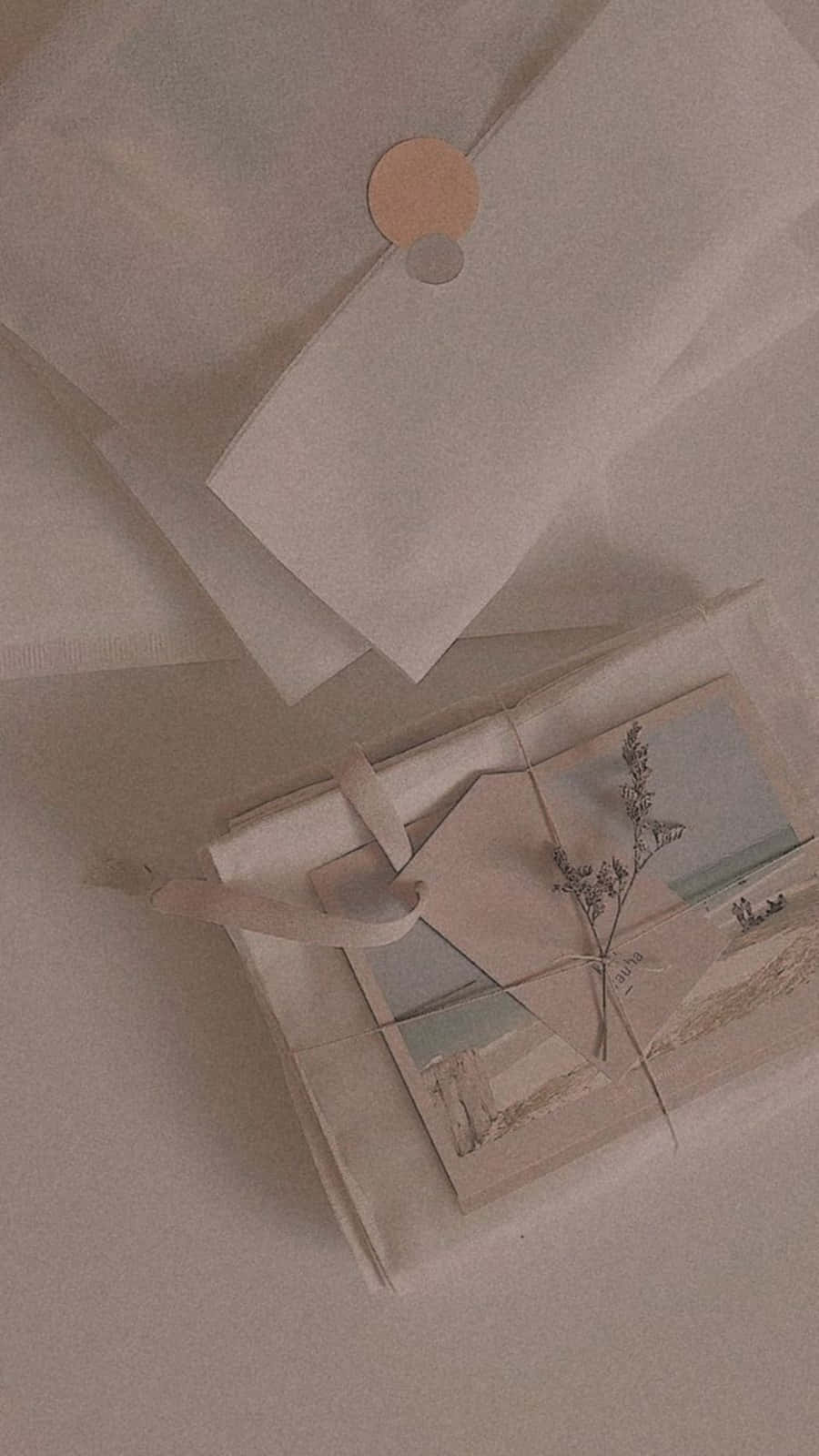 Korean Beige Aesthetic 桌布 壁紙 — 一個簡約的米色禮物盒，配有乾草和標籤，旁邊放著一個帶有圓形封條的折疊白色信封。