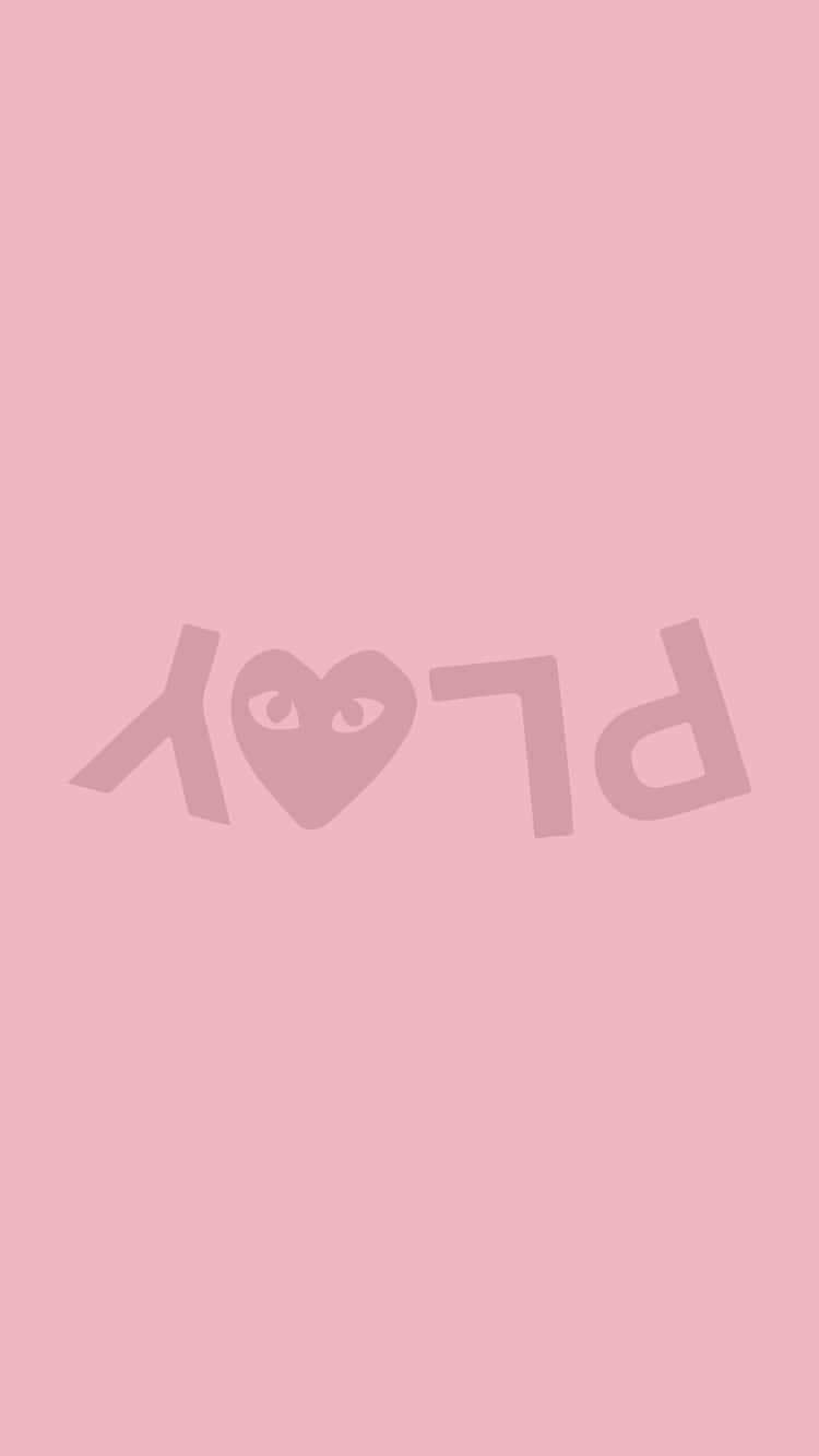 愛心 桌布 壁紙 — 一個簡約的粉紅色背景上顯示了「PLAY」這個詞，其中字母O被一個心形眼睛符號取代。