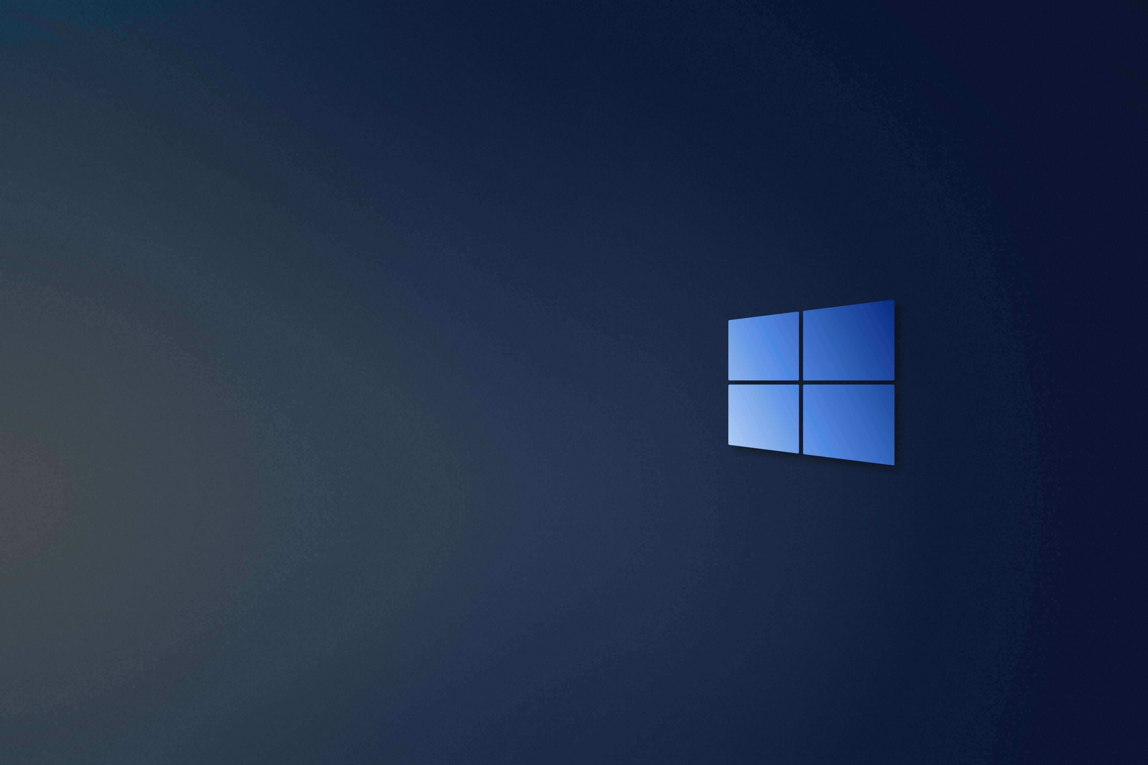 Dark Windows 桌布 壁紙 — 一個簡約的藍色Windows標誌，居中放置在帶有柔和光線的深色漸變背景上。