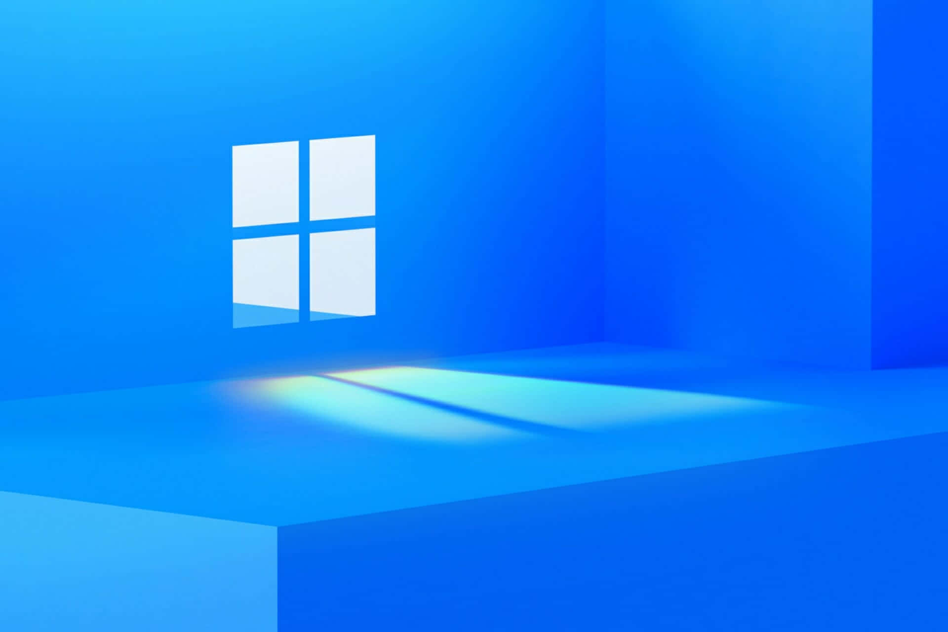 Windows Default 桌布 壁紙 — 一個簡約的藍色房間，發光的Windows標誌在地板上投射出柔和的光線。