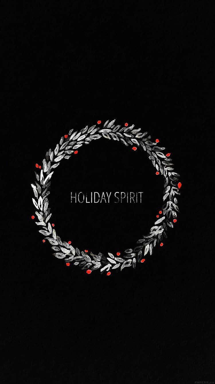 Christmas Wreath 桌布 壁紙 — 一個簡約的銀色花環，帶有紅色漿果，圍繞著文字 holiday spirit，背景為純黑色。