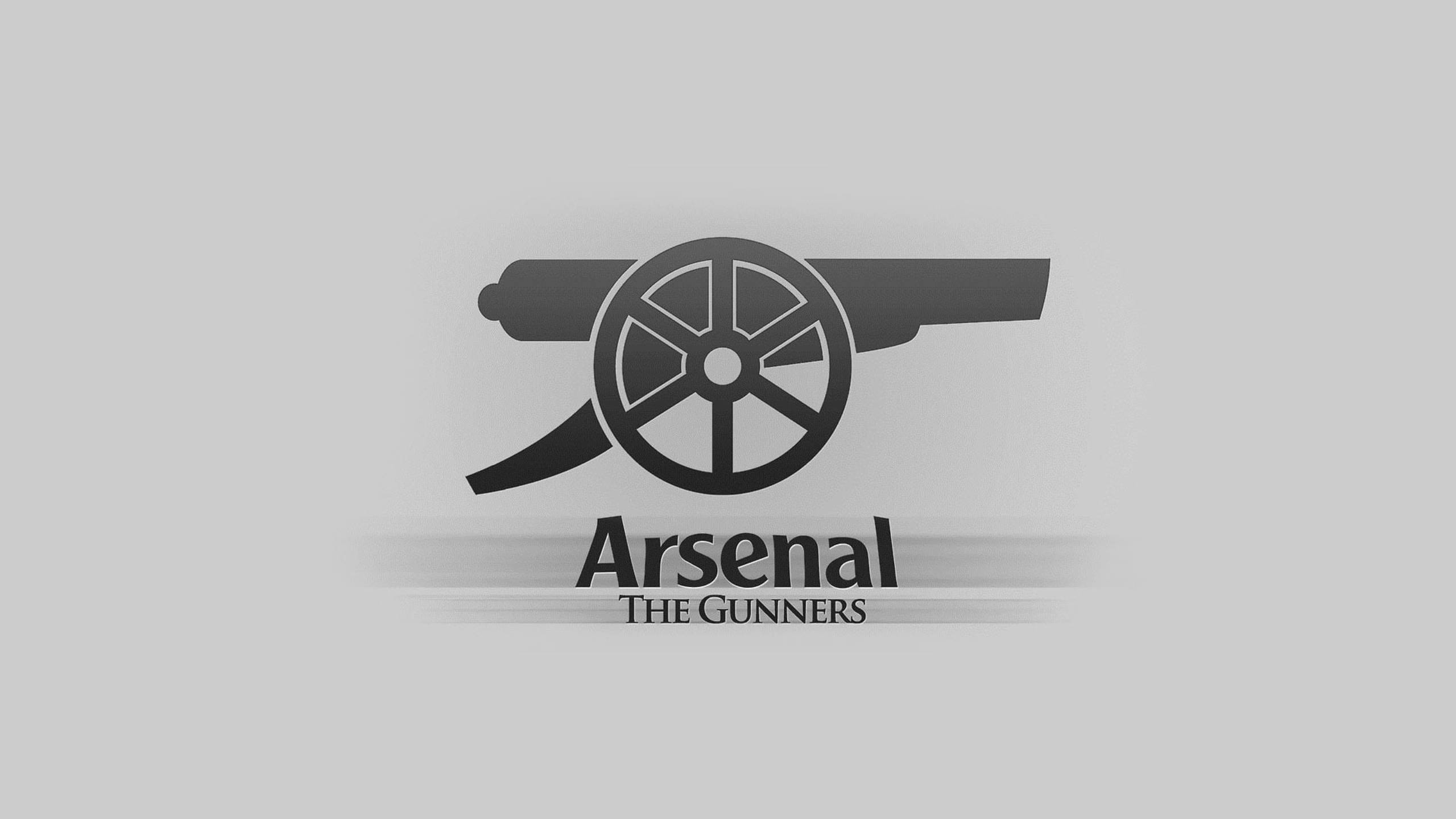 兵工廠 桌布 壁紙 — 一個簡約的黑白標誌，上面有一門大砲，下方有「Arsenal The Gunners」文字，背景為淺灰色。