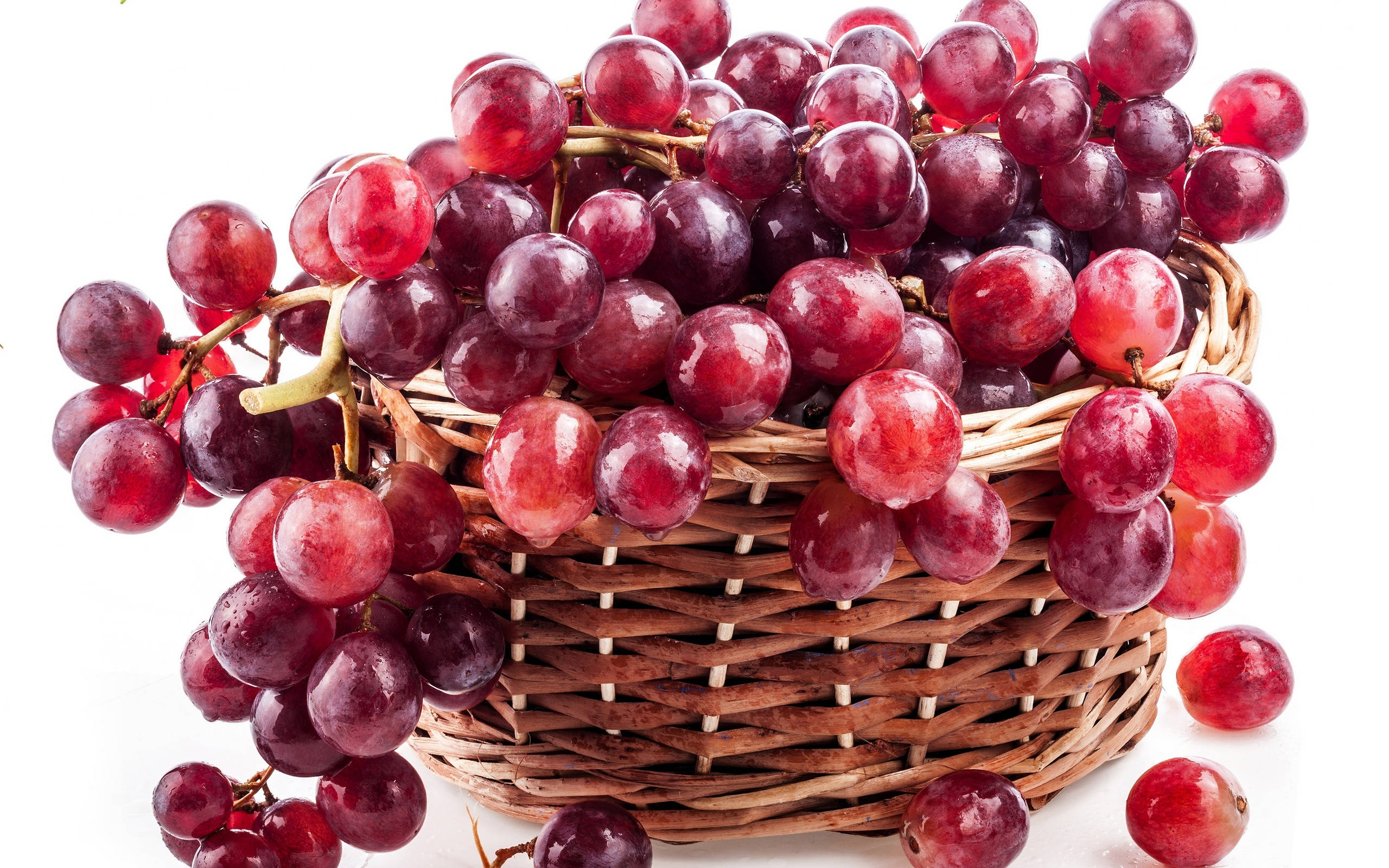 Grape 桌布 壁紙 — 一個籃子裝滿飽滿的紅葡萄，在純白背景上閃爍著露珠。