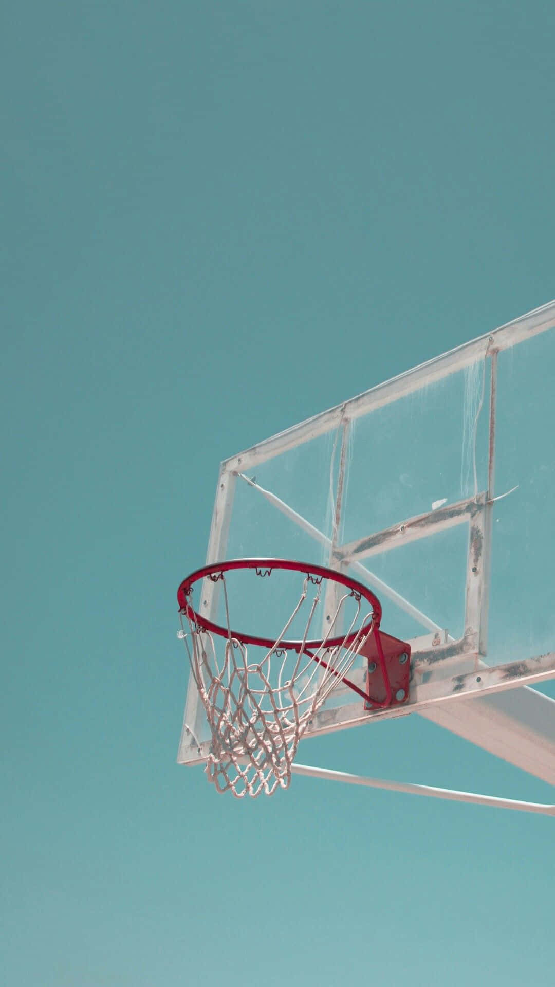 Basketball Aesthetic 桌布 壁紙 — 一個籃球框，紅色邊框和白色網，背景是清澈的藍綠色天空。