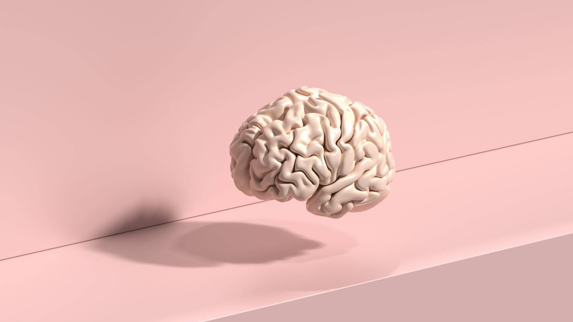 mind 桌布 壁紙 — 一個米色人腦模型漂浮在極簡粉色表面上，投射出柔和陰影。