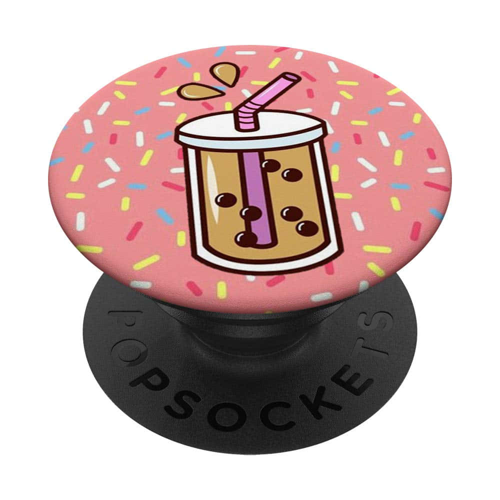 tea 桌布 壁紙 — 一個粉紅色PopSocket，上面有卡通珍珠奶茶杯和彩色糖粒，背景為白色。