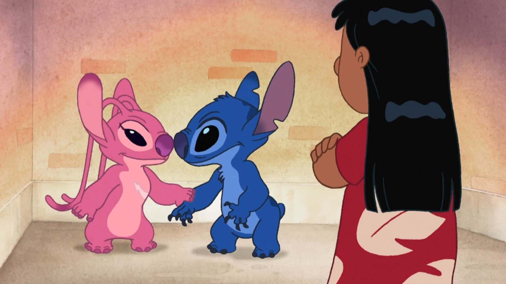 Love Stitch And Angel 桌布 壁紙 — 一個粉紅色和藍色的外星人組合在溫暖照明的房間裡牽手，而一個女孩交叉雙臂看著他們。