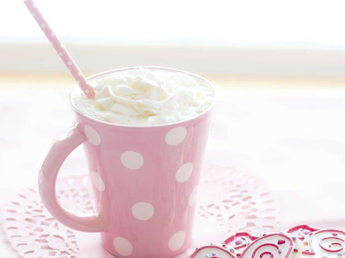 Hot Chocolate 桌布 壁紙 — 一個粉紅色圓點杯裝滿鮮奶油和吸管，放在蕾絲杯墊上，旁邊有裝飾餅乾。