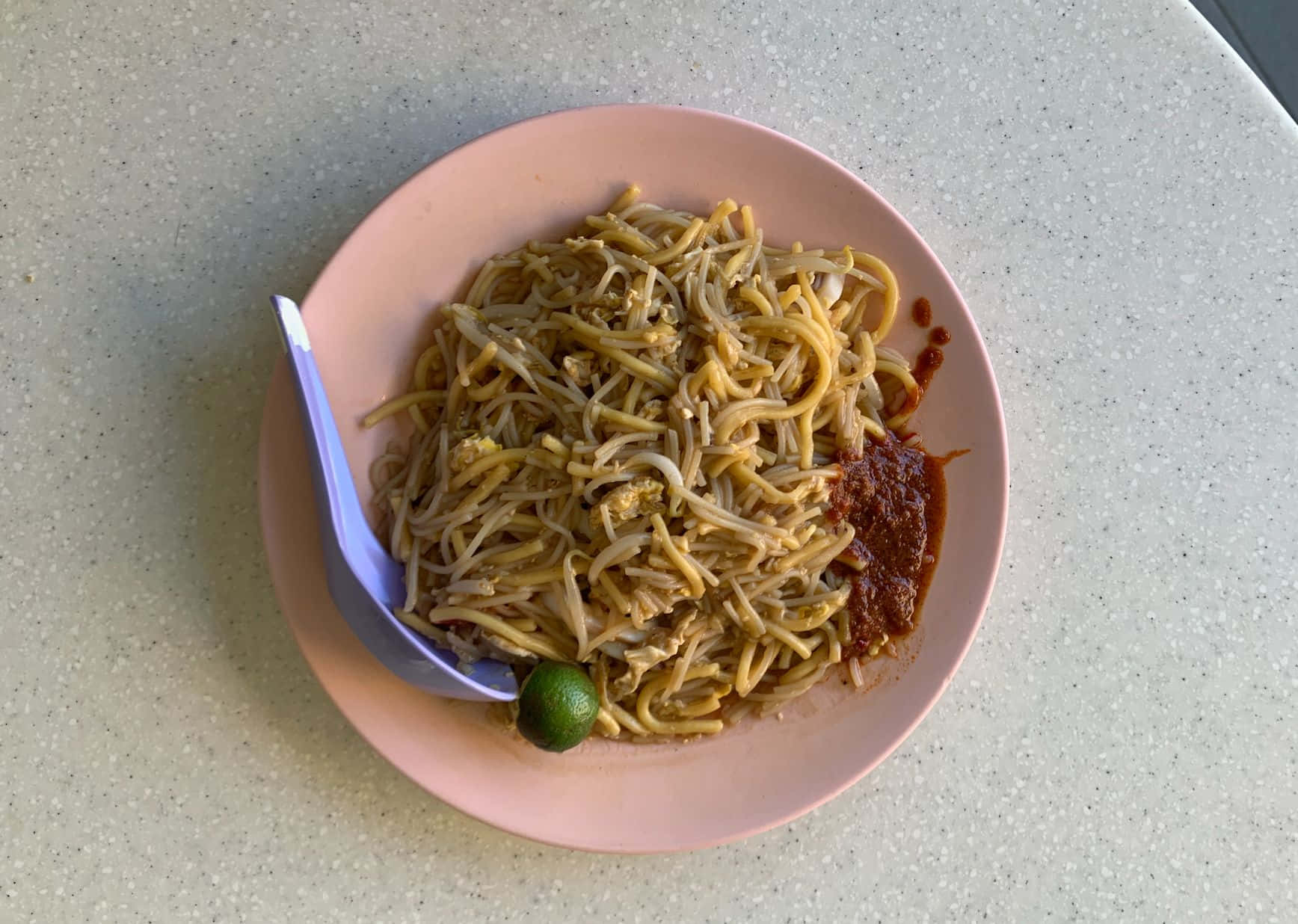 Delicious Food 桌布 壁紙 — 一個粉紅色盤子盛裝著炒麵、豆芽和萊姆角，放在有斑點的檯面上。