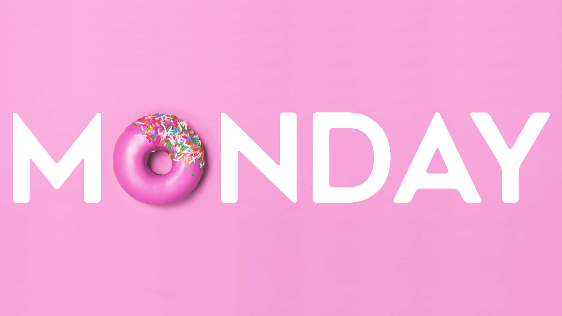 Monday 桌布 壁紙 — 一個粉紅色糖霜甜甜圈配上彩色糖粒，取代了MONDAY一詞中的字母O，背景為純粉紅色。