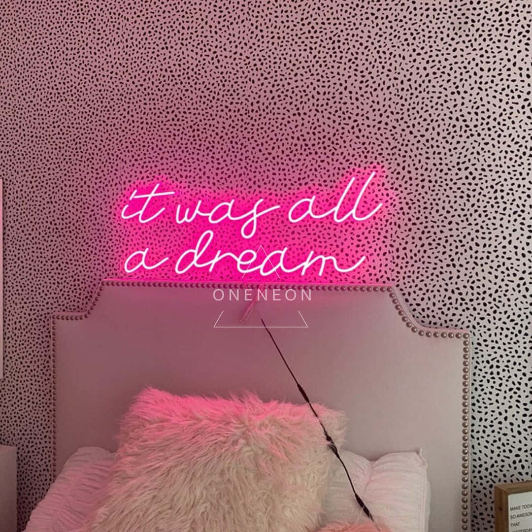 neon sign 桌布 壁紙 — 一個粉紅色霓虹燈牌寫著 it was all a dream，在鋪有柔軟枕頭的床上方發光，背景是斑點壁紙。