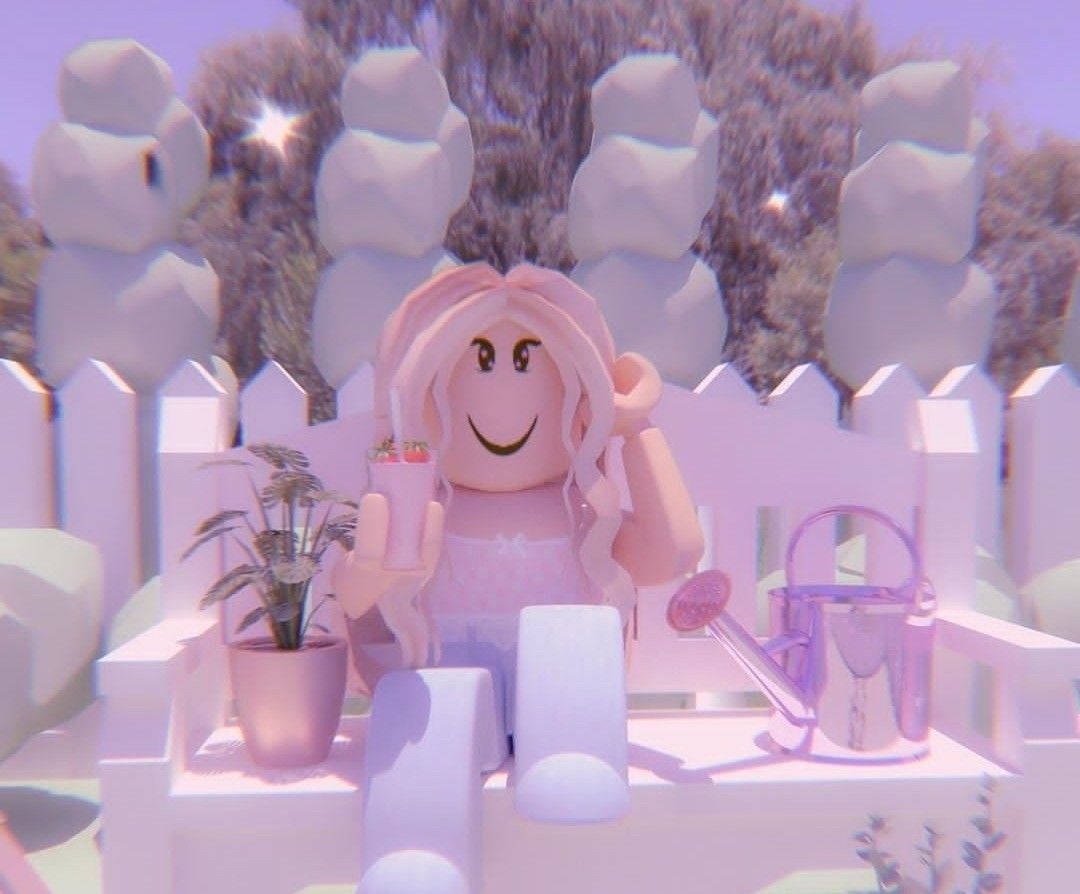 美學 Roblox 女孩 桌布 壁紙 — 一個粉紅色頭髮的Roblox頭像微笑著，在白色長椅上拿著飲料，旁邊有一盆盆栽和一個澆水壺。