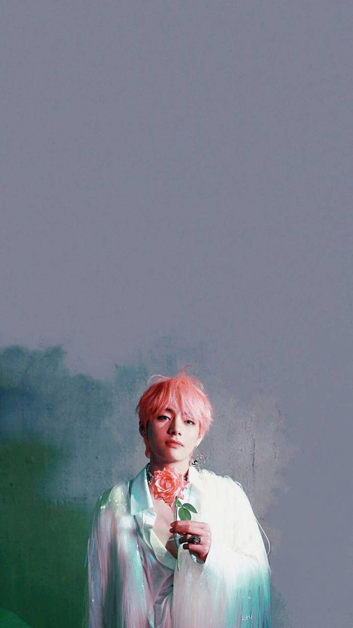 Taehyung Cute 桌布 壁紙 — 一個粉紅色頭髮的人拿著一朵玫瑰，背景是紫色和綠色的柔和漸變。