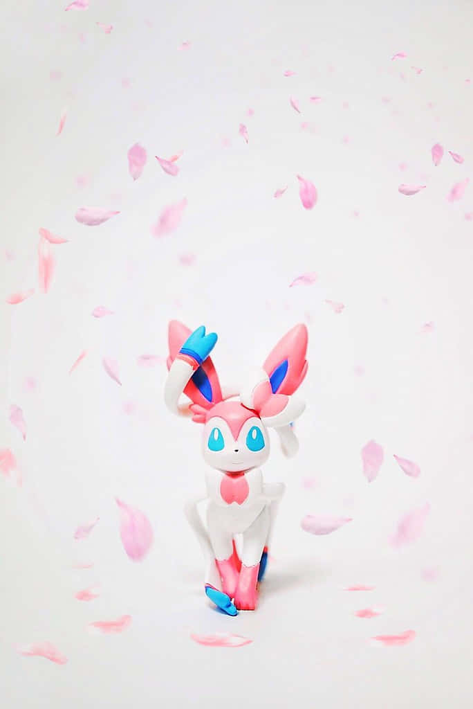 Pokemon Figures 桌布 壁紙 — 一個粉藍色的Sylveon公仔站在柔軟白色背景上飄落的櫻花花瓣之間。