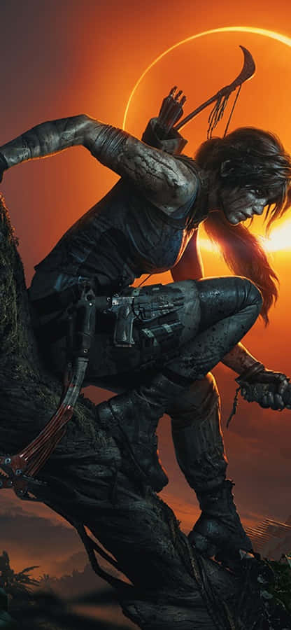 iPhone X Shadow Of The Tomb Raider 桌布 壁紙 — 一個粗獷的冒險家在日落時分蹲在懸崖邊，揮舞著戰斧和弓，對抗火橙色的天空。