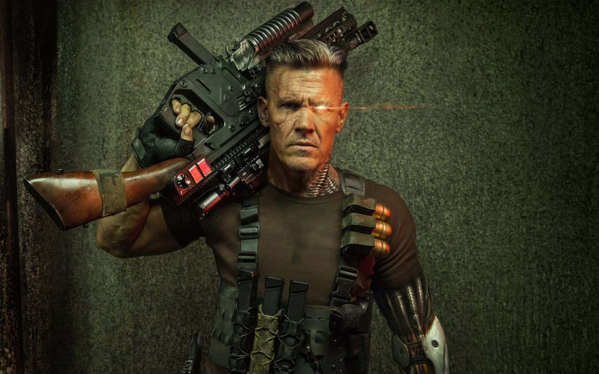 Deadpool 2 桌布 壁紙 — 一個粗獷的動作英雄，配備機械義肢和重型武器，對著深色紋理牆壁凝視。