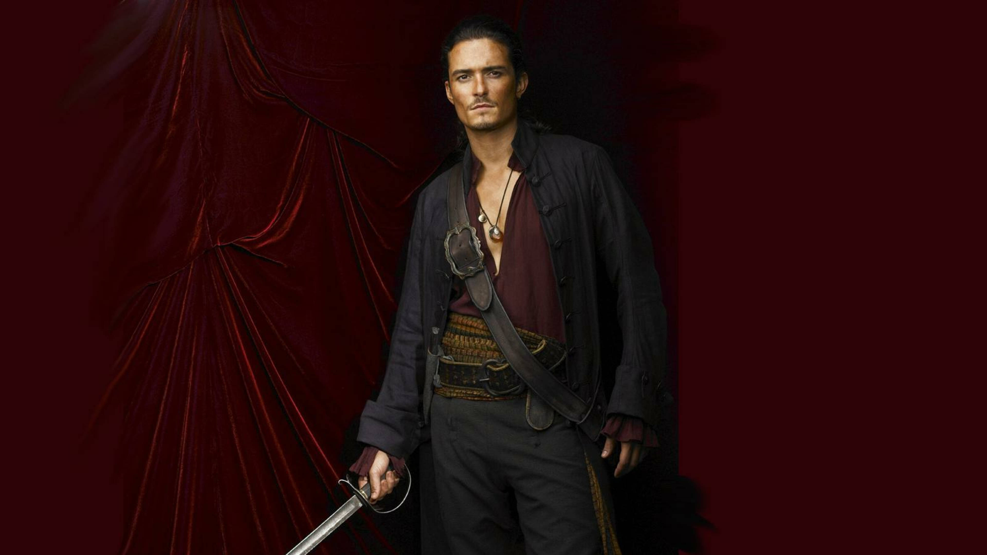 Pirates Of The Caribbean 桌布 壁紙 — 一個粗獷的海盜手持劍，站在戲劇性的紅色天鵝絨幕布前，營造出陰鬱的攝影棚肖像。