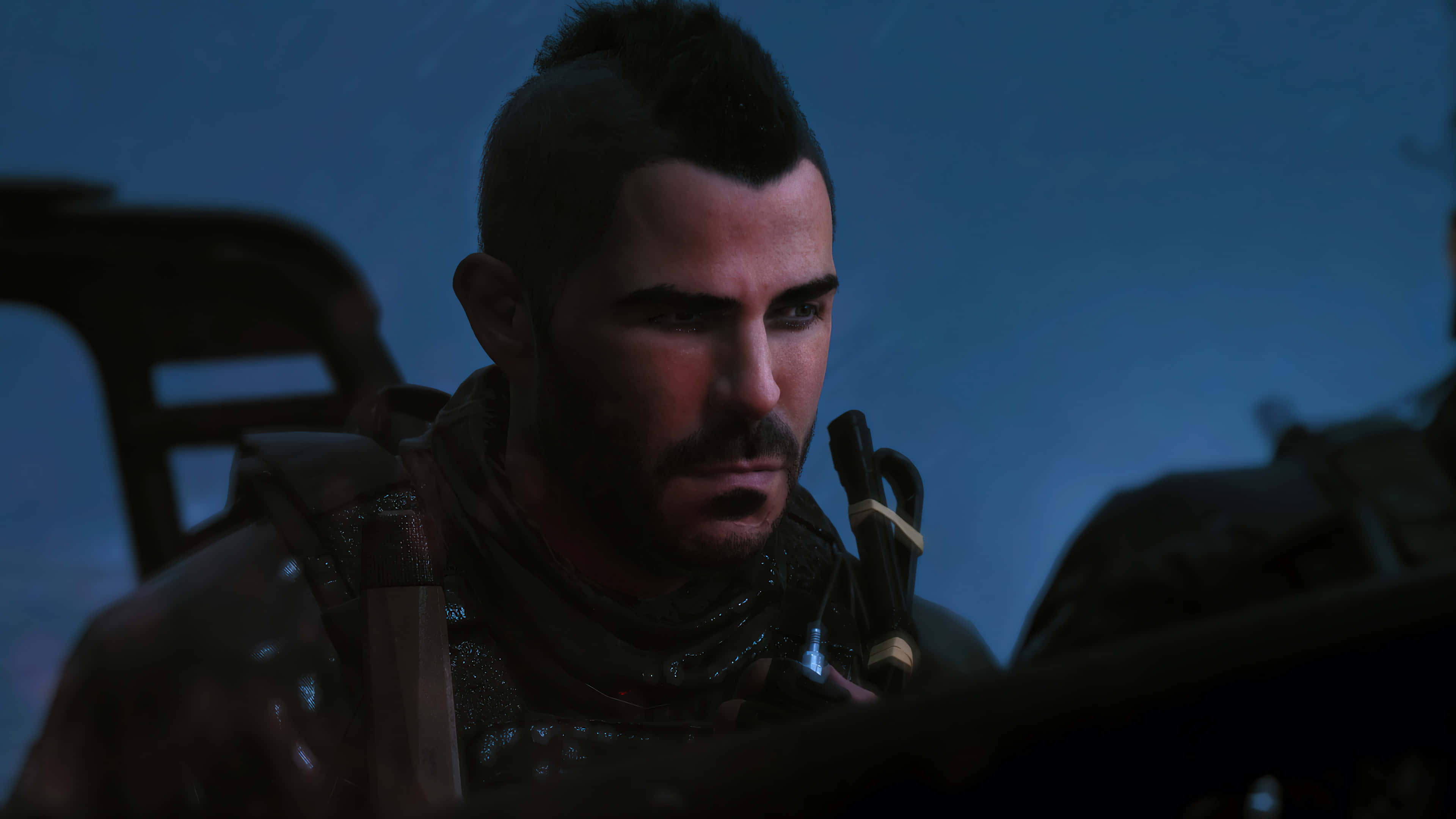 Soap Mactavish 桌布 壁紙 — 一個粗獷的男人，留著莫霍克頭和鬍鬚，在暮色天空下昏暗的車輛內凝視著。