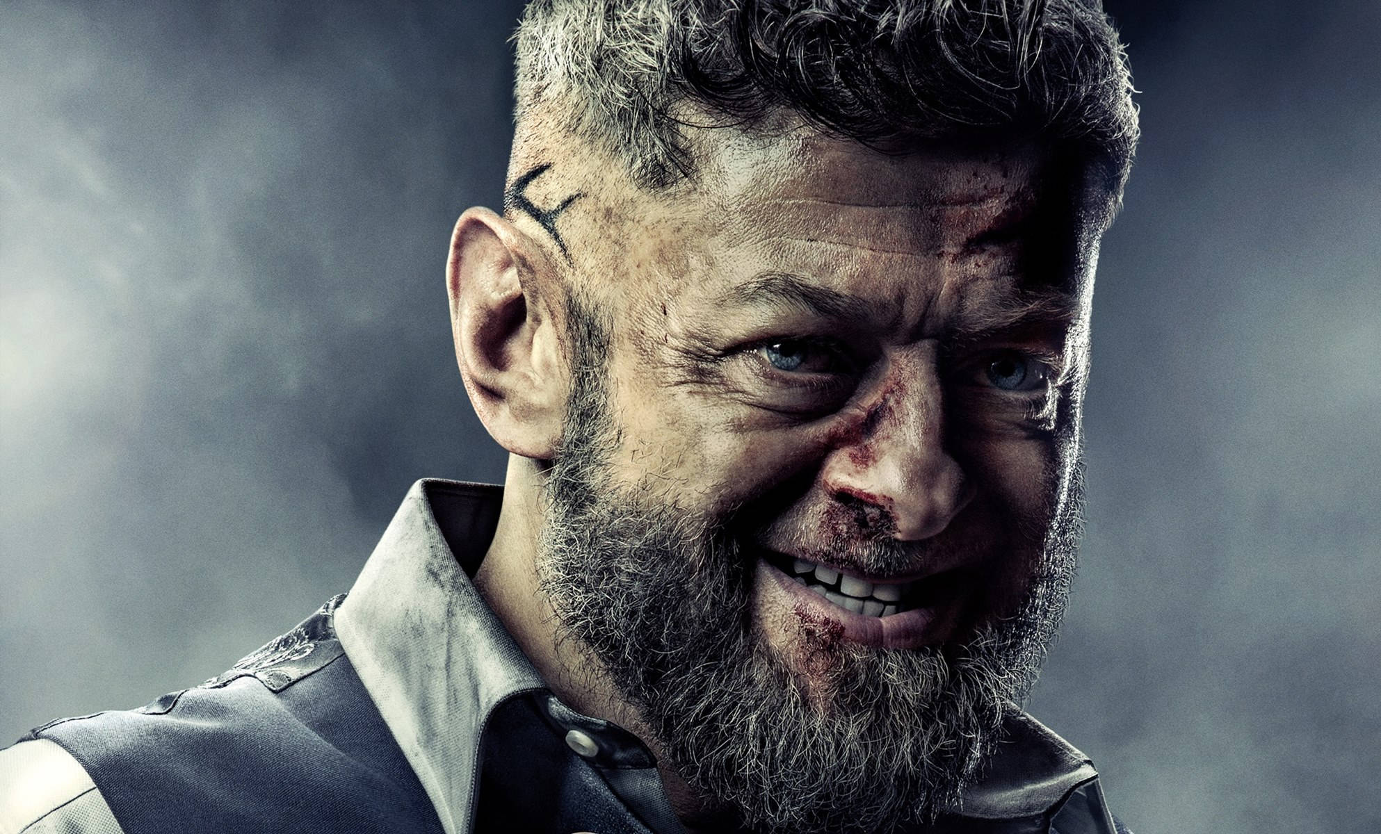 actor 桌布 壁紙 — 一個粗獷的男人，臉上和鬍鬚沾滿血，在煙霧瀰漫的灰色背景下露出兇猛的笑容。