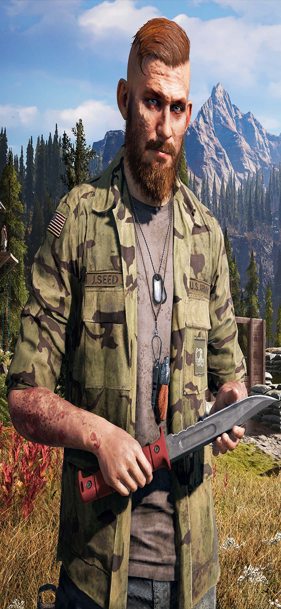 iPhone Xs Far Cry 5 桌布 壁紙 — 一個粗獷的鬍鬚士兵身穿迷彩服，在群山森林背景下握著一把血淋淋的刀。
