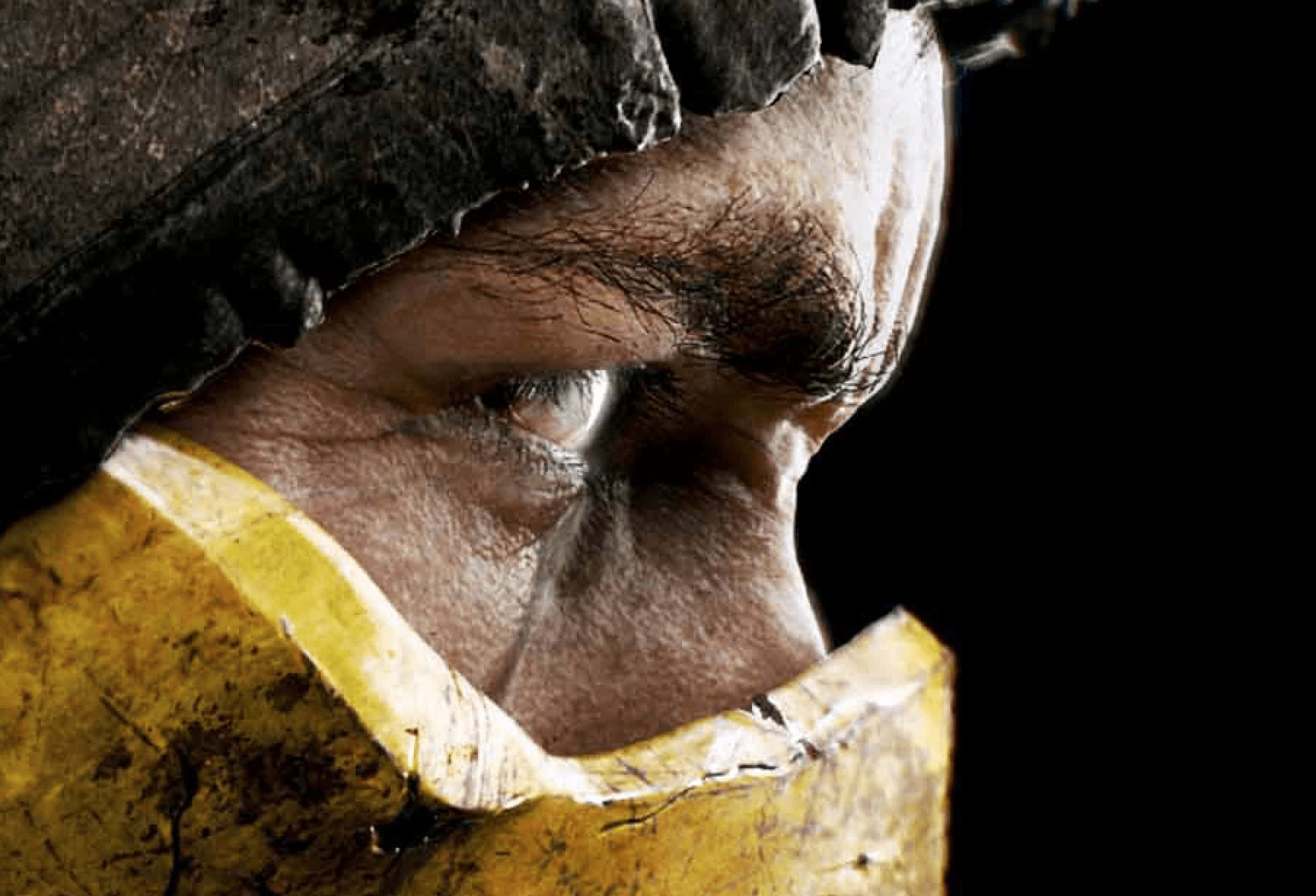 Mortal Kombat X 桌布 壁紙 — 一個粗糙的特寫鏡頭，捕捉到一個男人透過撕裂的黃色布料窺視的強烈眼睛，背景為黑色。