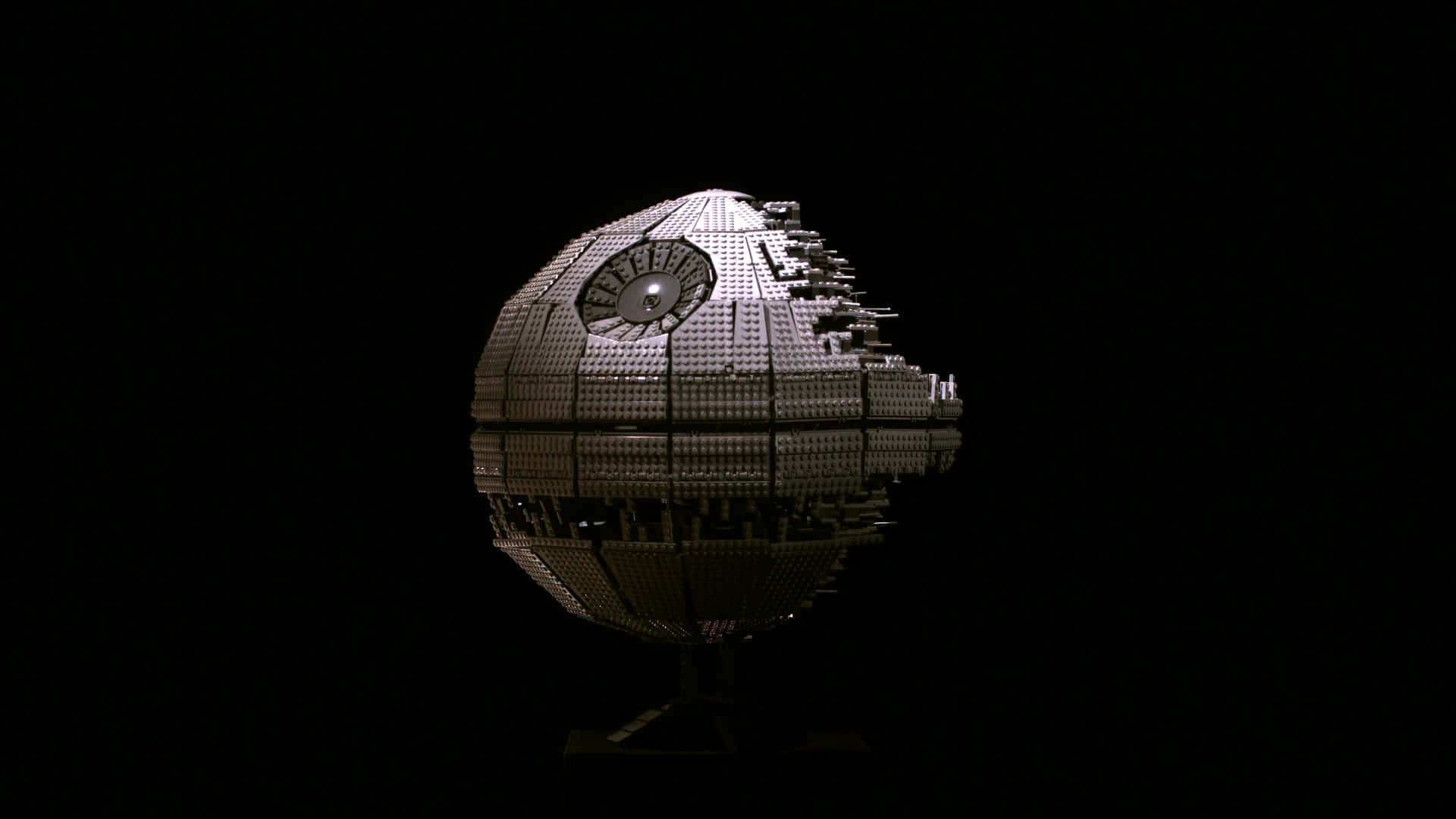 Death Star 桌布 壁紙 — 一個精細的LEGO死星模型，在黑色背景上照亮，下方有反射表面。
