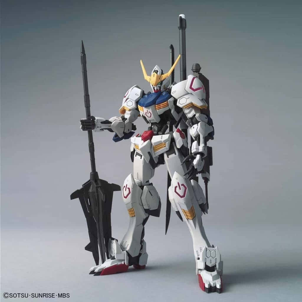 Mobile Suit Gundam Iron-blooded Orphans 桌布 壁紙 — 一個精細的白色、藍色和金色鋼彈模型，手持一把巨大的黑色長矛，站在樸素的灰色攝影棚背景前。