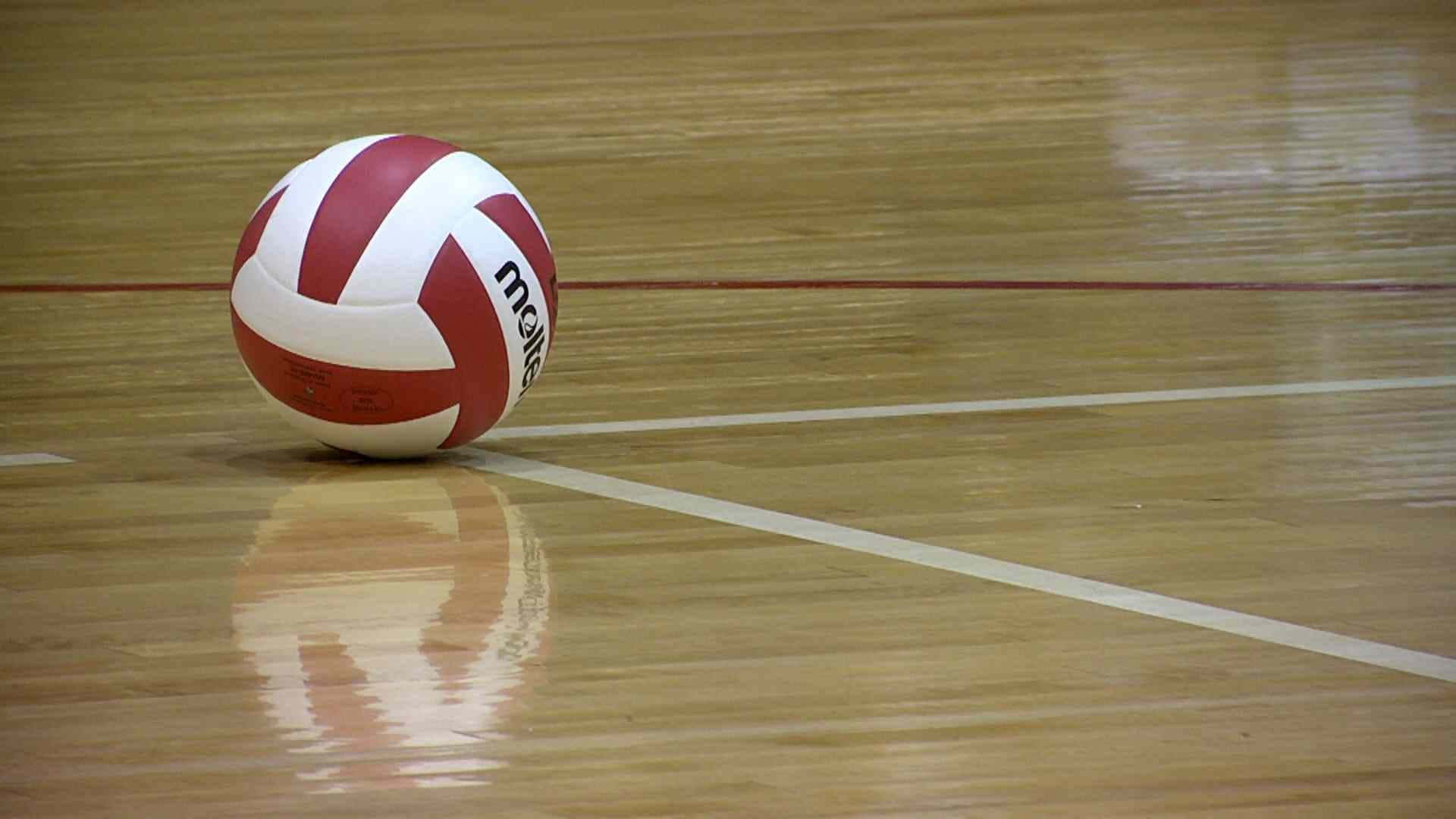 運動 桌布 壁紙 — 一個紅白相間的排球放在拋光木地板上，清晰的白線在其下方柔和地反射。