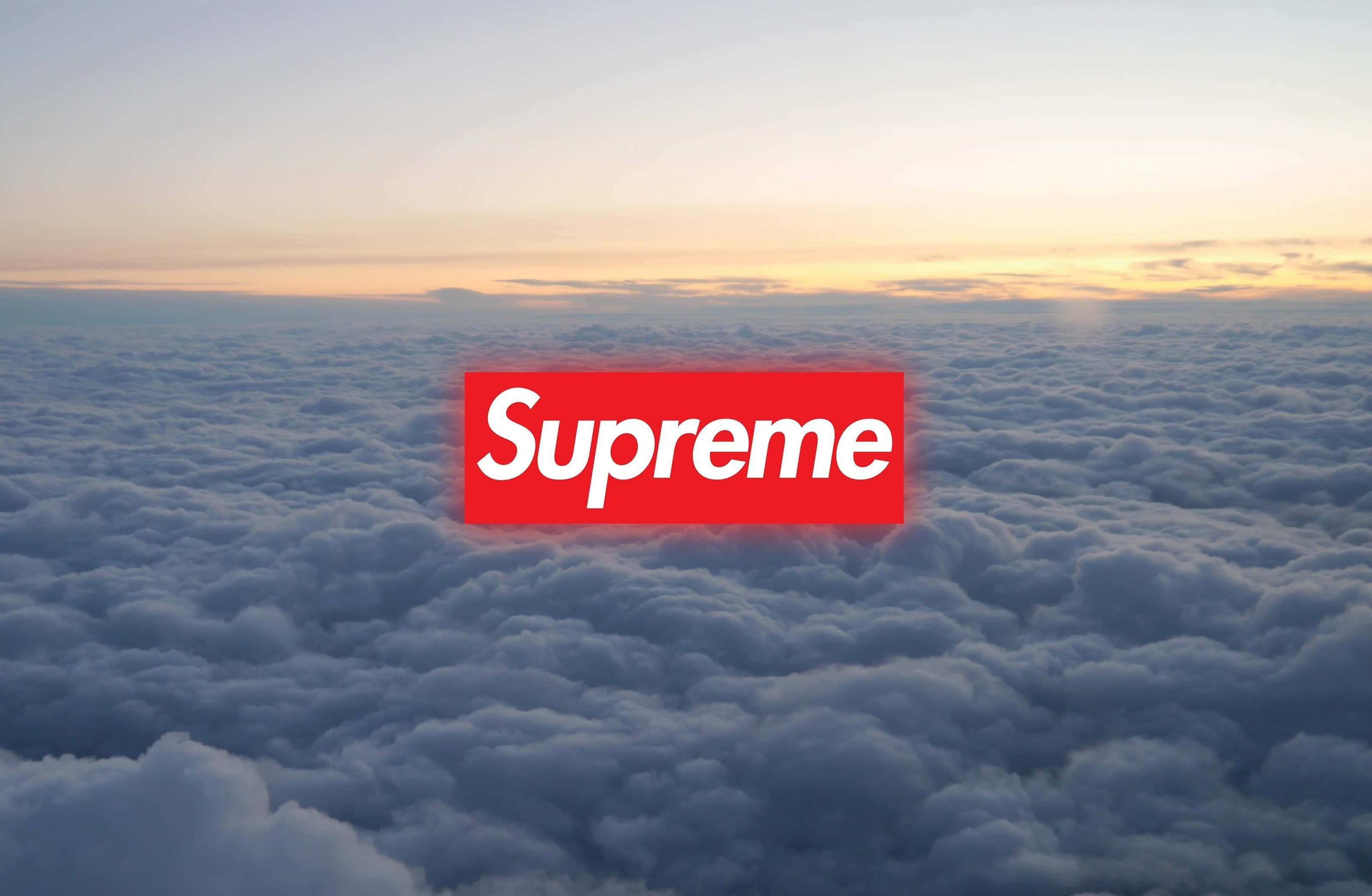 雲朵 桌布 壁紙 — 一個紅色Supreme標誌漂浮在日出時分的雲海之上，帶有柔和的橙色和藍色色調。