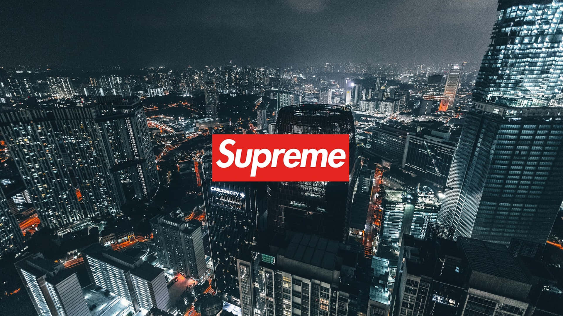 紅色Supreme標誌疊加在夜間城市天際線上，建築物燈火通明。 — Supreme GIF 壁紙