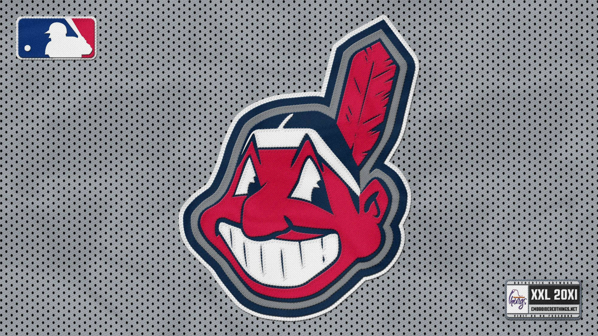 Cleveland Indians 桌布 壁紙 — 一個紅色卡通美洲原住民吉祥物標誌，帶有羽毛，背景為灰色網眼棒球球衣。