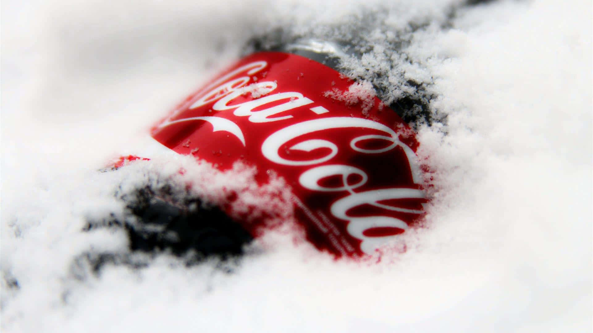 coca cola 桌布 壁紙 — 一個紅色可口可樂瓶半埋在潔白的新雪中，表面附著霜。