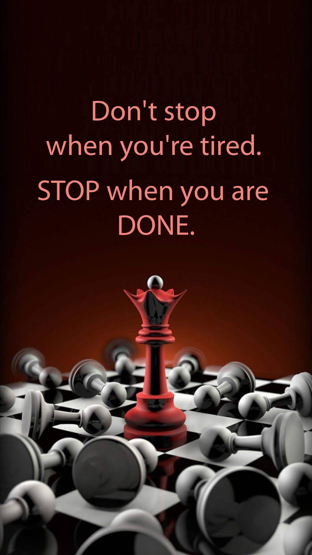 Encouraging 桌布 壁紙 — 一個紅色國王棋子在棋盤上勝利地站立，周圍是被擊倒的白色棋子，在溫暖的燈光下。
