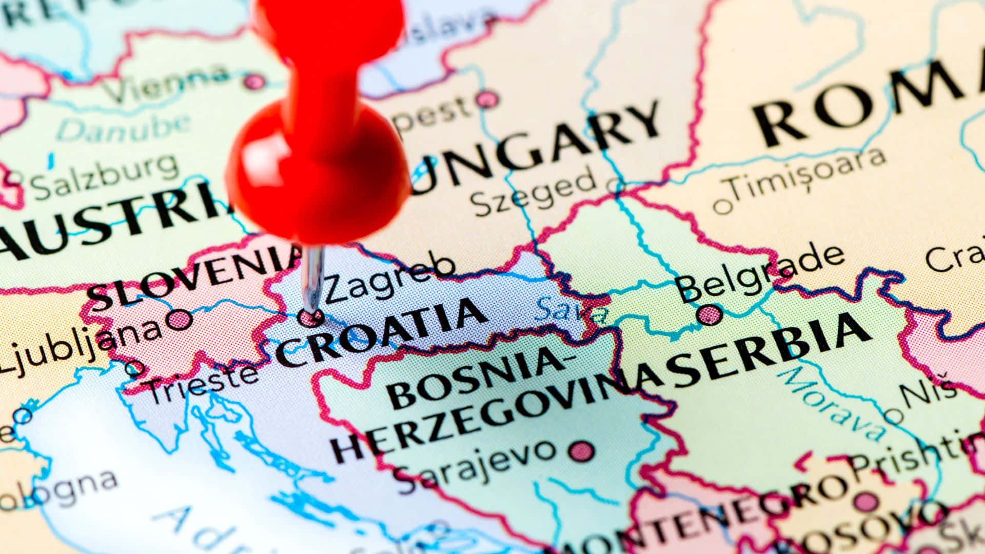 Croatia 桌布 壁紙 — 一個紅色圖釘標記克羅埃西亞在色彩繽紛的政治地圖上，鄰近國家清晰可見的特寫。