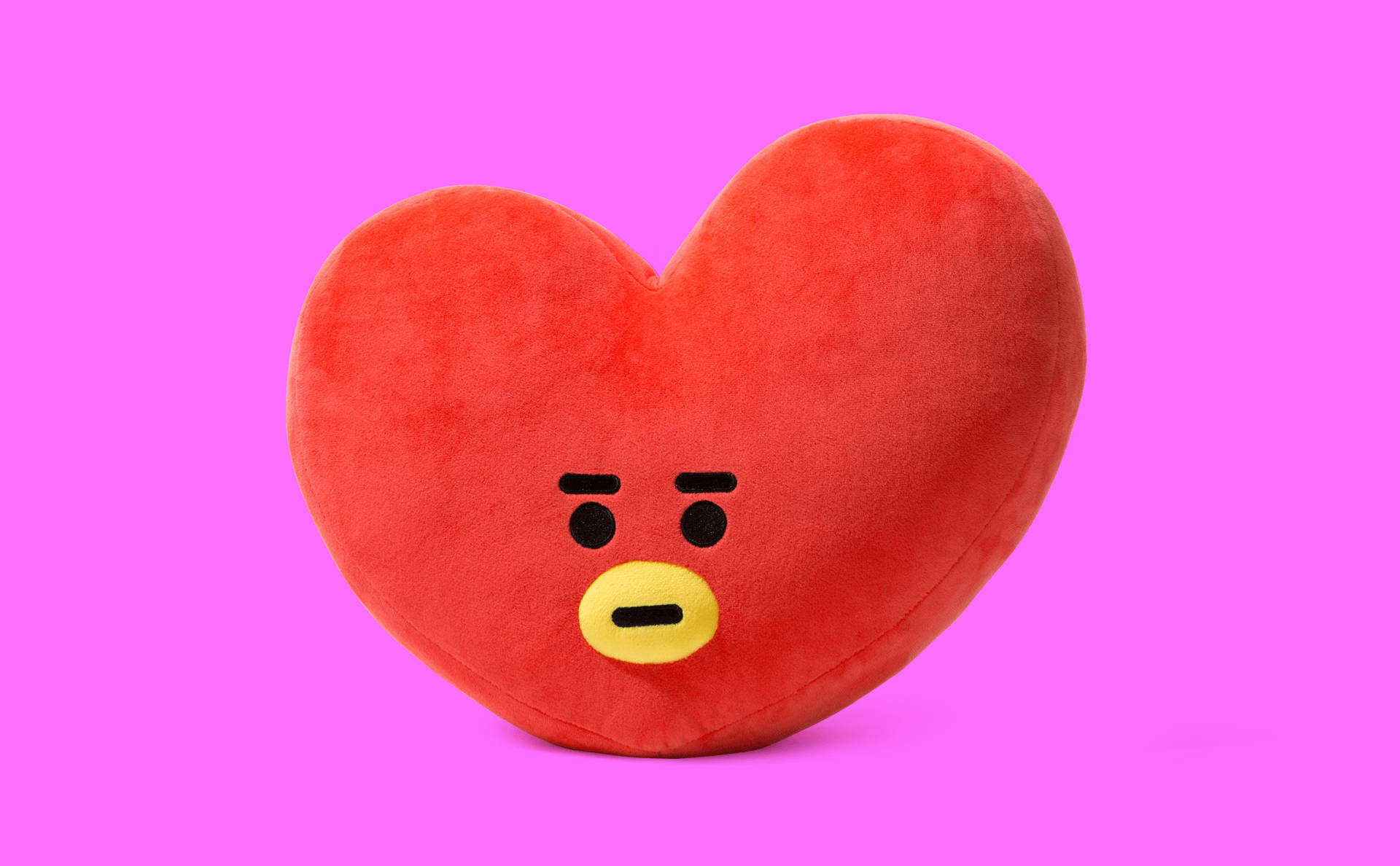 tata bt21 桌布 壁紙 — 一個紅色心形毛絨玩具，帶著不高興的表情，放在充滿活力的粉紅色背景前。