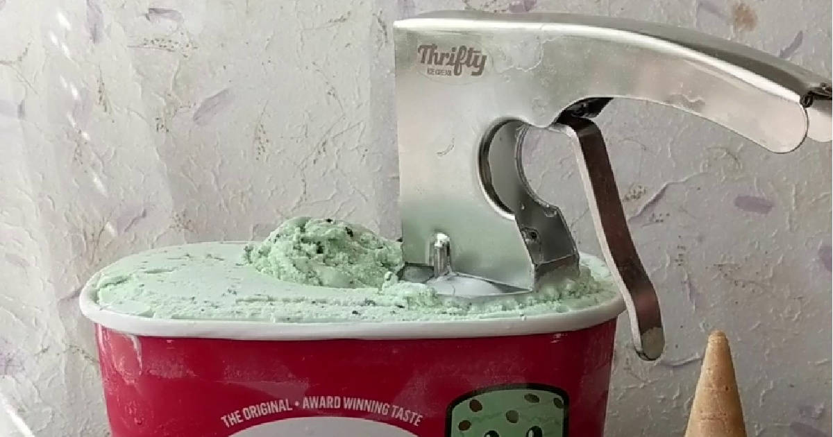 Ice Cream 桌布 壁紙 — 一個紅色的薄荷巧克力碎片冰淇淋桶，搭配銀色Thrifty冰淇淋勺，部分舀出奶油狀綠色冰淇淋，背景是有紋理的白色牆壁。