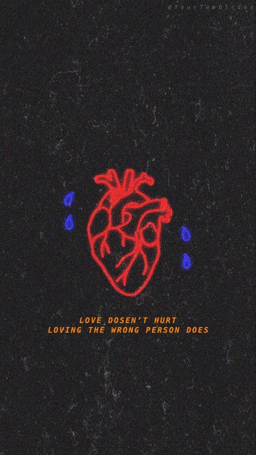 Sad Quotes 桌布 壁紙 — 一個紅色解剖學心臟，帶有藍色眼淚，位於有紋理的黑色背景上，下方有橙色文字。