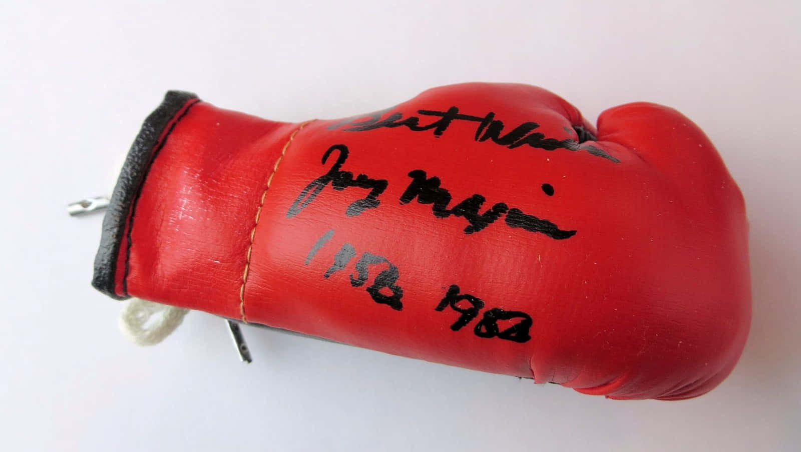 Boxing 桌布 壁紙 — 一個紅色迷你拳擊手套，帶有黑色墨水簽名和日期 1958 1980，白色背景。