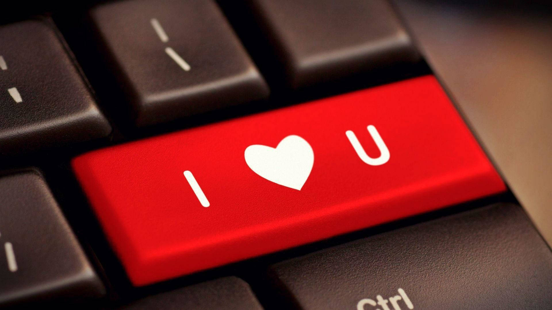 I Love You Aesthetic 桌布 壁紙 — 一個紅色鍵盤鍵的特寫，上面有白色文字 I heart U，周圍環繞著黑色按鍵。