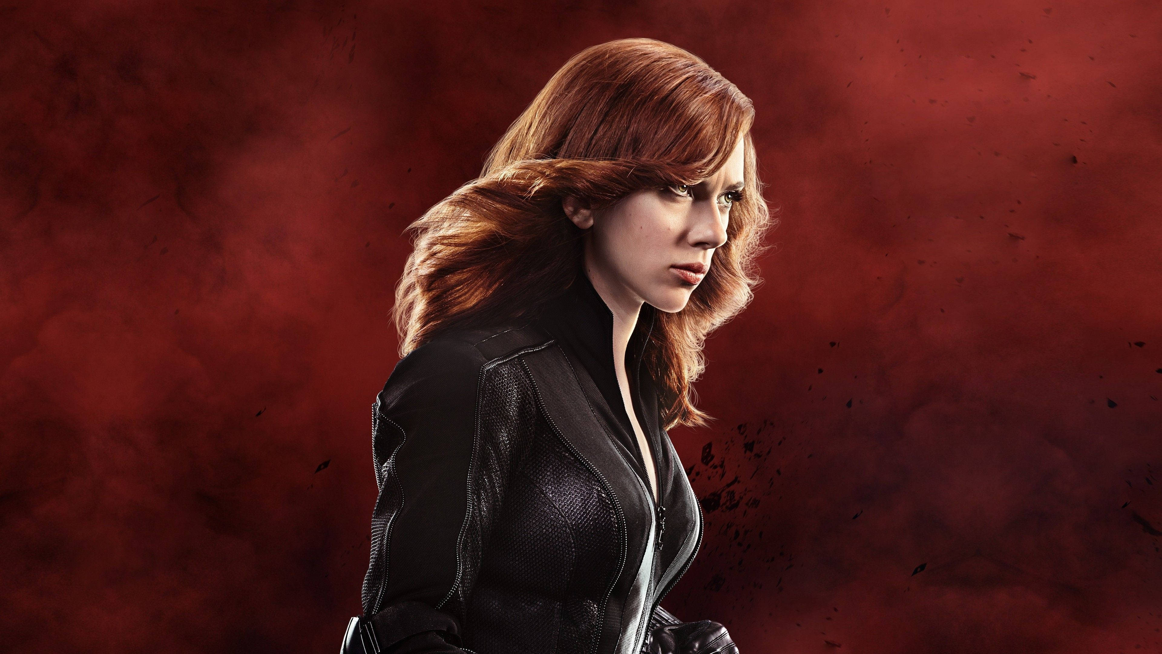 Scarlett Johansson Black Widow 桌布 壁紙 — 一個紅髮的兇猛女人穿著黑色皮夾克，站在煙霧瀰漫的深紅色背景前。