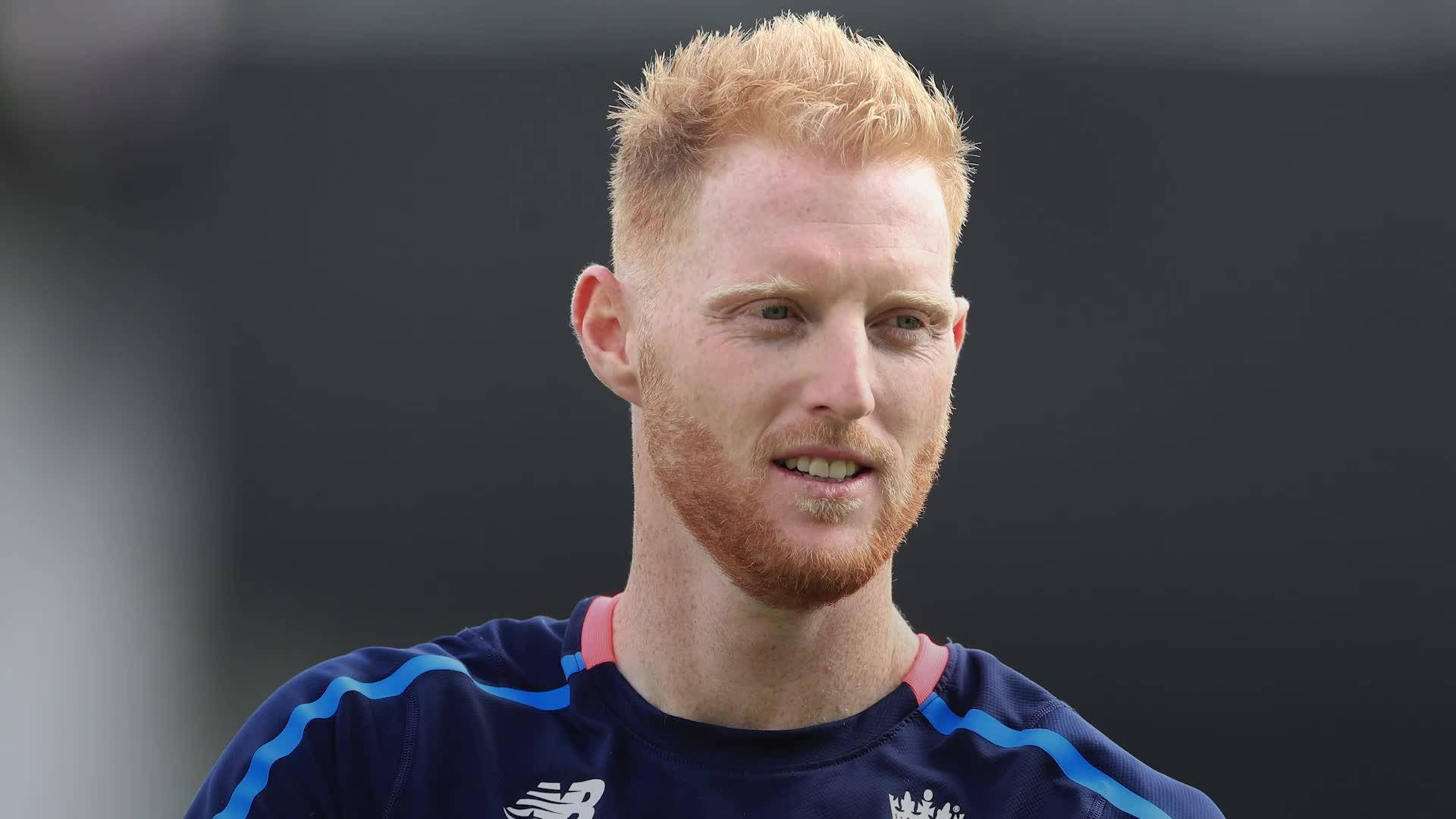 Ben Stokes 桌布 壁紙 — 一個紅髮鬍鬚男的近距離特寫，穿著藍色運動衫，背景為深色。