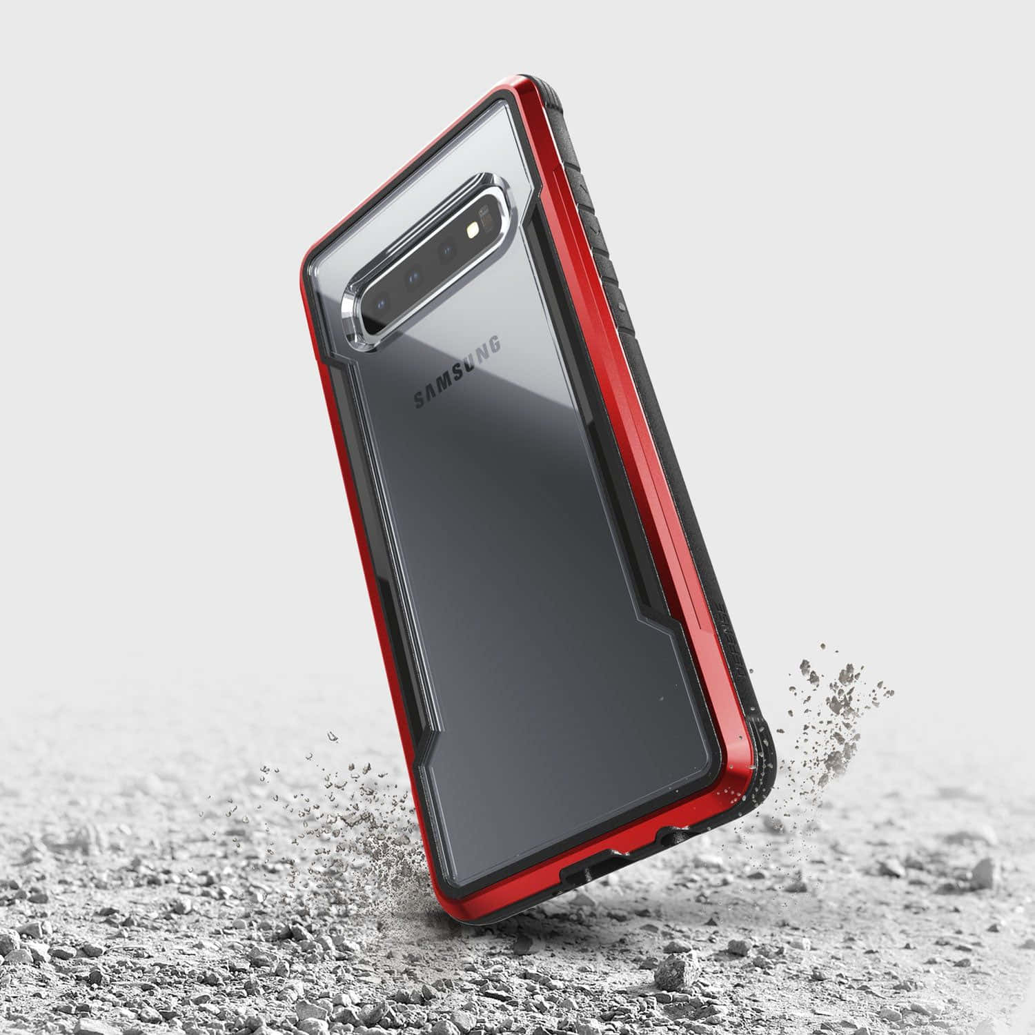Galaxy S10 桌布 壁紙 — 一個紅黑配色堅固的Samsung手機殼撞擊碎石，揚起灰塵的動態動作鏡頭。