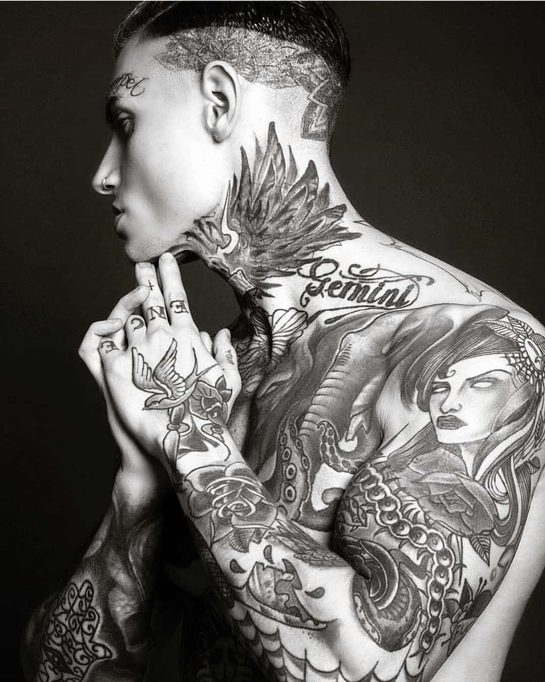 Tattoo Boy 桌布 壁紙 — 一個紋身男子的黑白側面肖像，複雜的紋身覆蓋了他的頸部、肩膀和手臂。